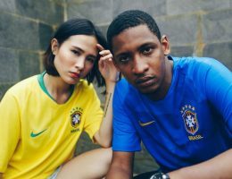 Homem e mulher vestidos com camisas do Brasil