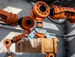 Robô industrial colaborando com operador humano na automação de fábricas, demonstrando a integração entre robôs e operadores no ambiente fabril.